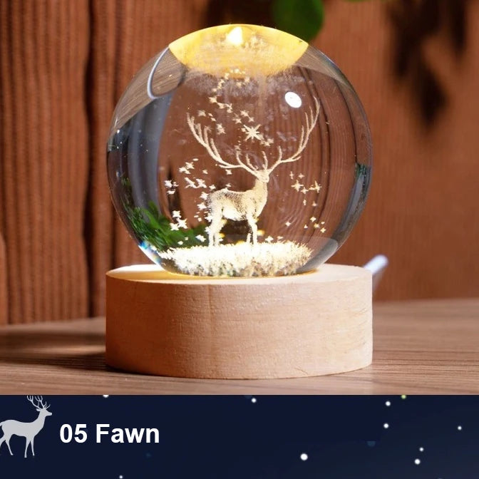 Decorative glass ball with a deer inside on a wooden base, against a wooden background.