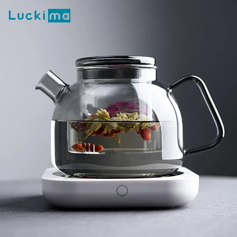 Glass teapot with blooming tea on electric coffee warmer by Luckima