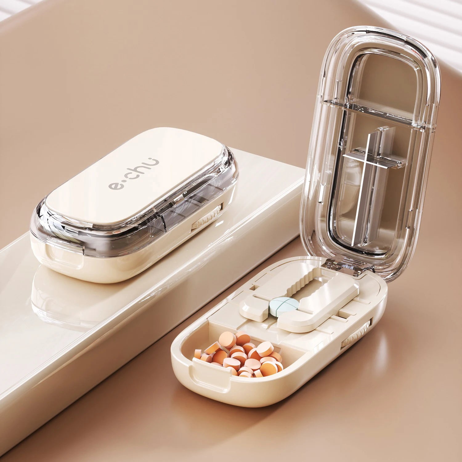 Beige Adjustable Pill Cutter by e.chu, labeled as Halve Pill Cutter, open with pills in compartments, shown with a closed unit.
