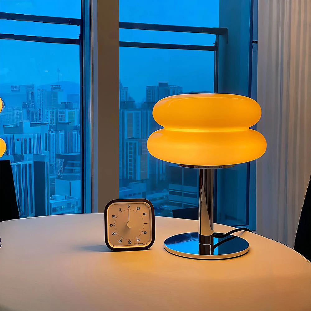 Modern stool with a glowing seat in a room with large windows showing a cityscape.