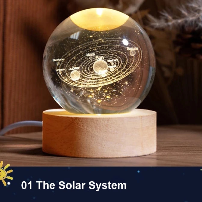 Glass sphere with solar system model on a wooden base, glowing softly.